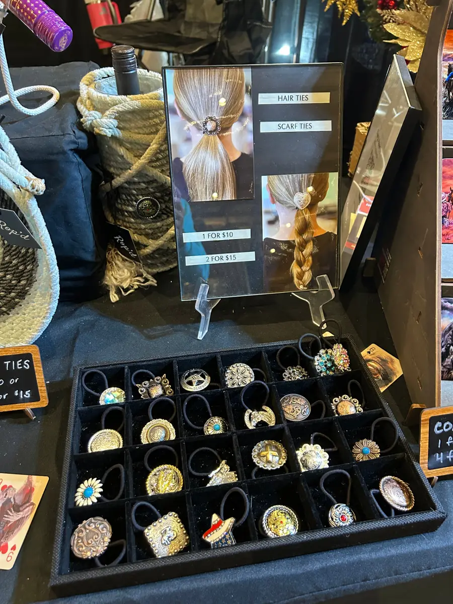 Tray of handcrafted concho hair ties and scarf ties on display